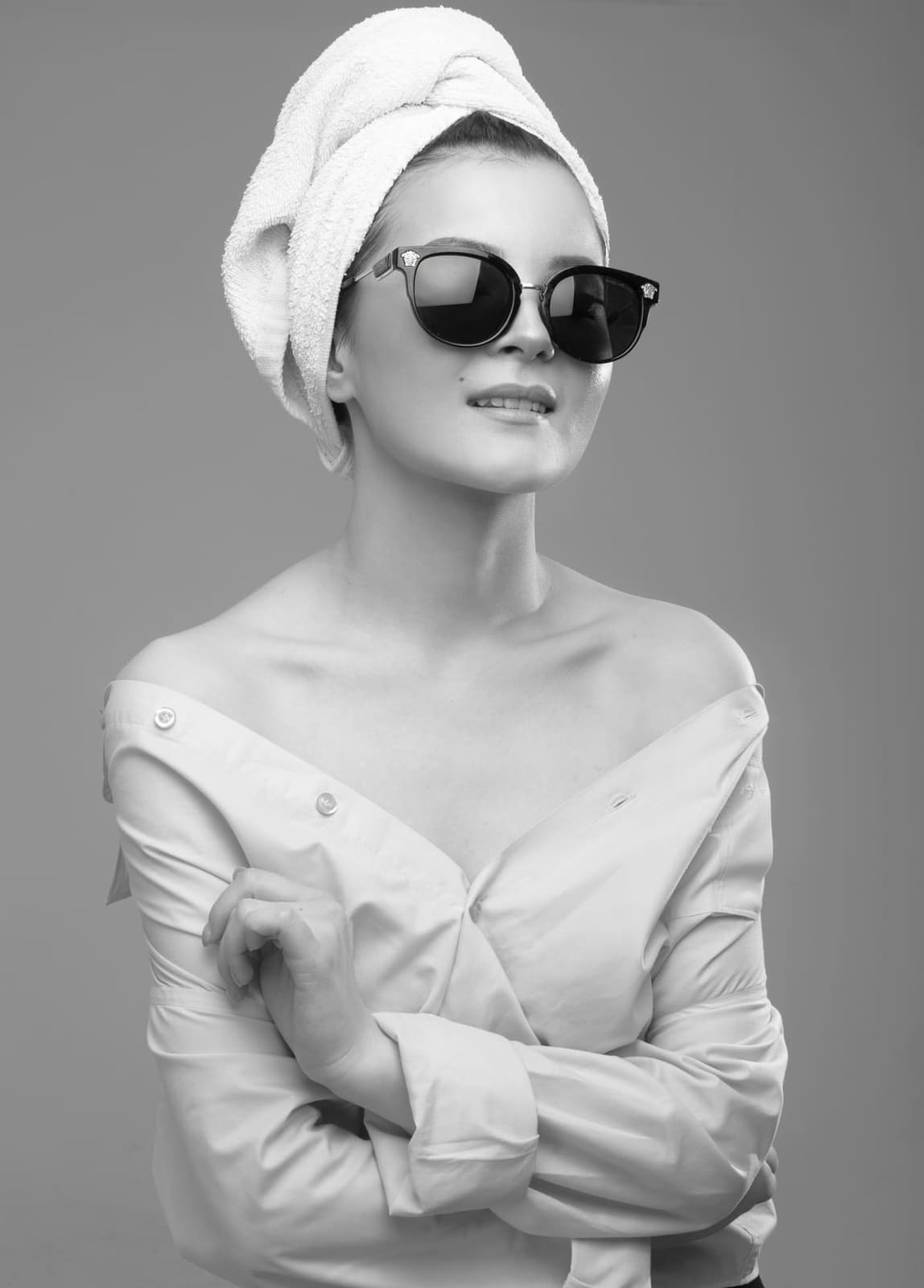 A bride-to-be in a towel turban and dark sunglasses, ready for the chair.