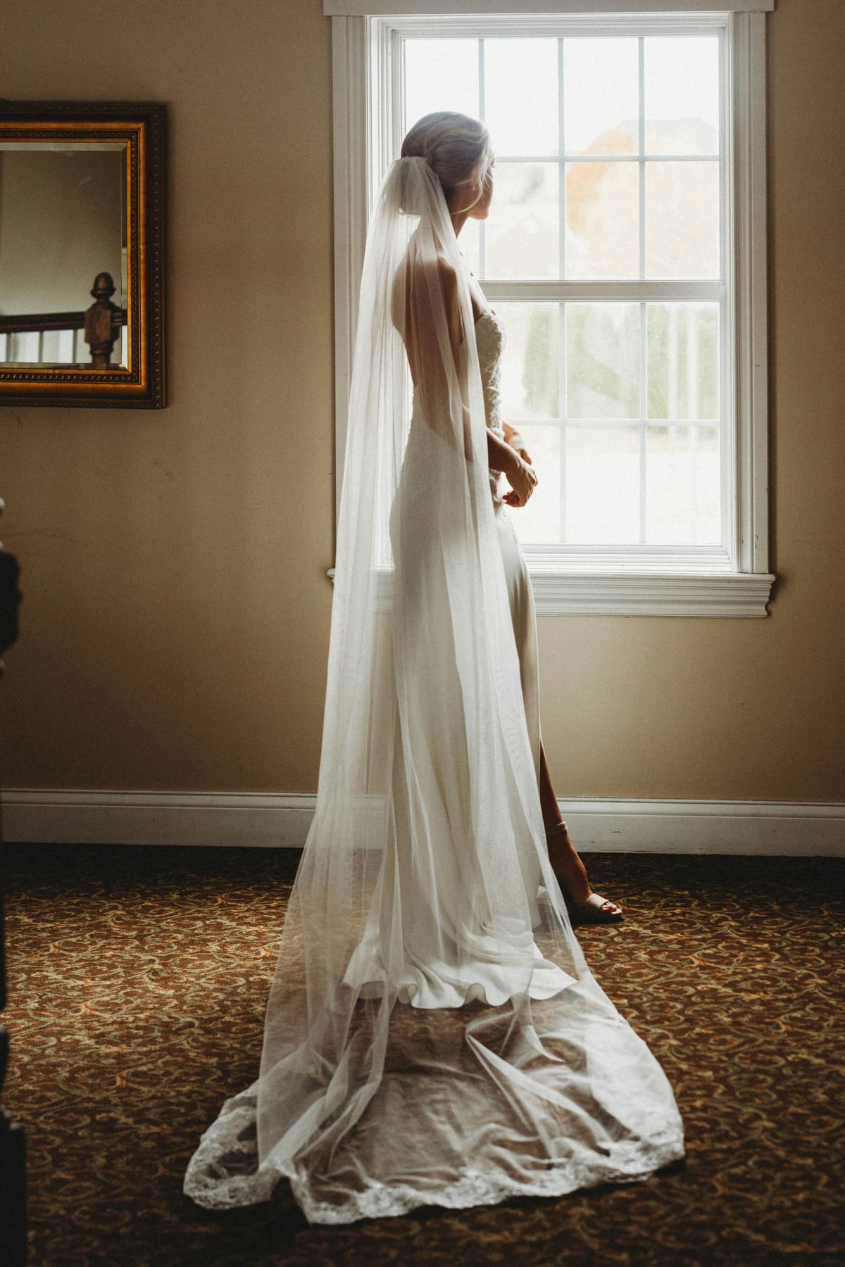 A wedding gown catching the light by a sunlit window